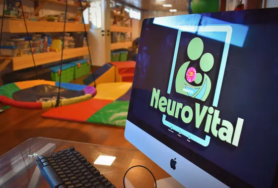 Oficina de NeuroVital con computador mostrando el logo del centro