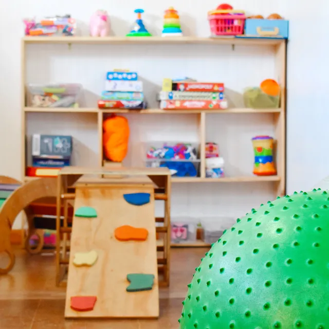 Estante con juegos y materiales de estimulación en la sala de terapia
