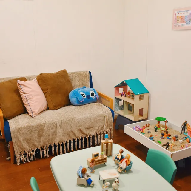 Sala de juego terapéutico con casa de muñecas